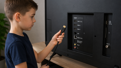 Дитина тримає HDMI-кабель біля роз'ємів телевізора, готуючись підключити ноутбук або інший пристрій. Фото демонструє дротове підключення телевізора через HDMI.